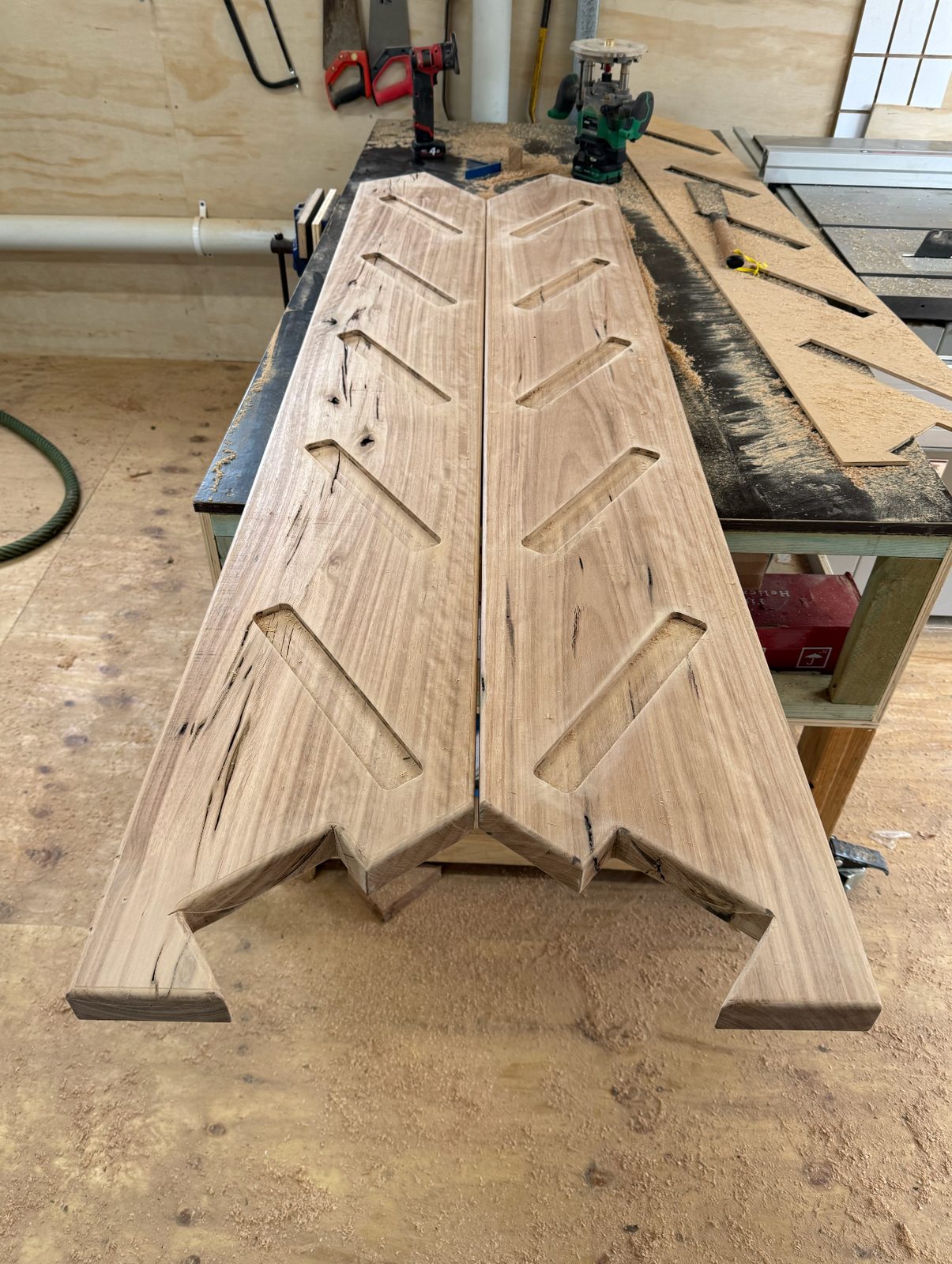 Solid timber stair stringers and joinery components on a workshop bench